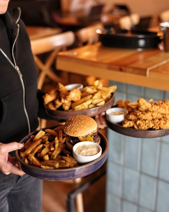 Farfurii cu smash burger, crispy chicken și cartofi prăjiți